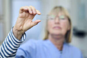 Mitarbeiterin einer Tierarztpraxis hält einen Teststreifen zur Untersuchung vor sich in die Höhe.