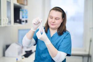 Tiermedizinische Fachangestellte im Labor untersucht eine Probe in einem Reagenzglas.