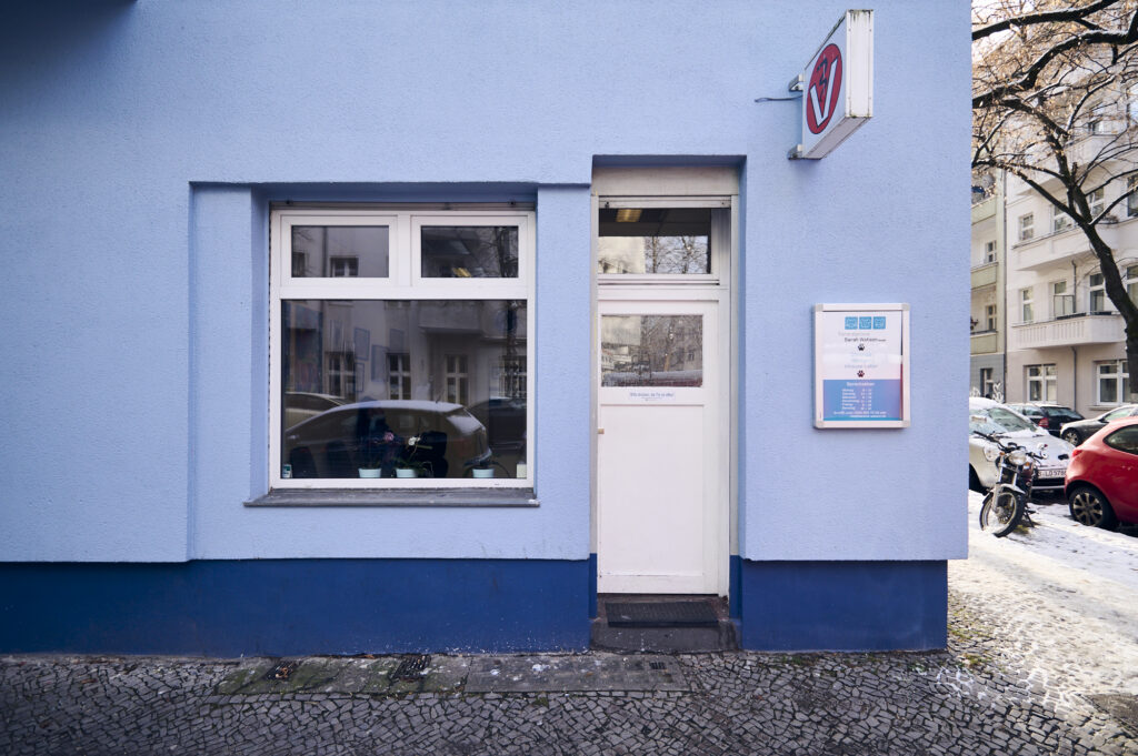 Außenansicht einer Tierarztpraxis mit Eingangstür, Fenster und Praxisschild an der Fassade.